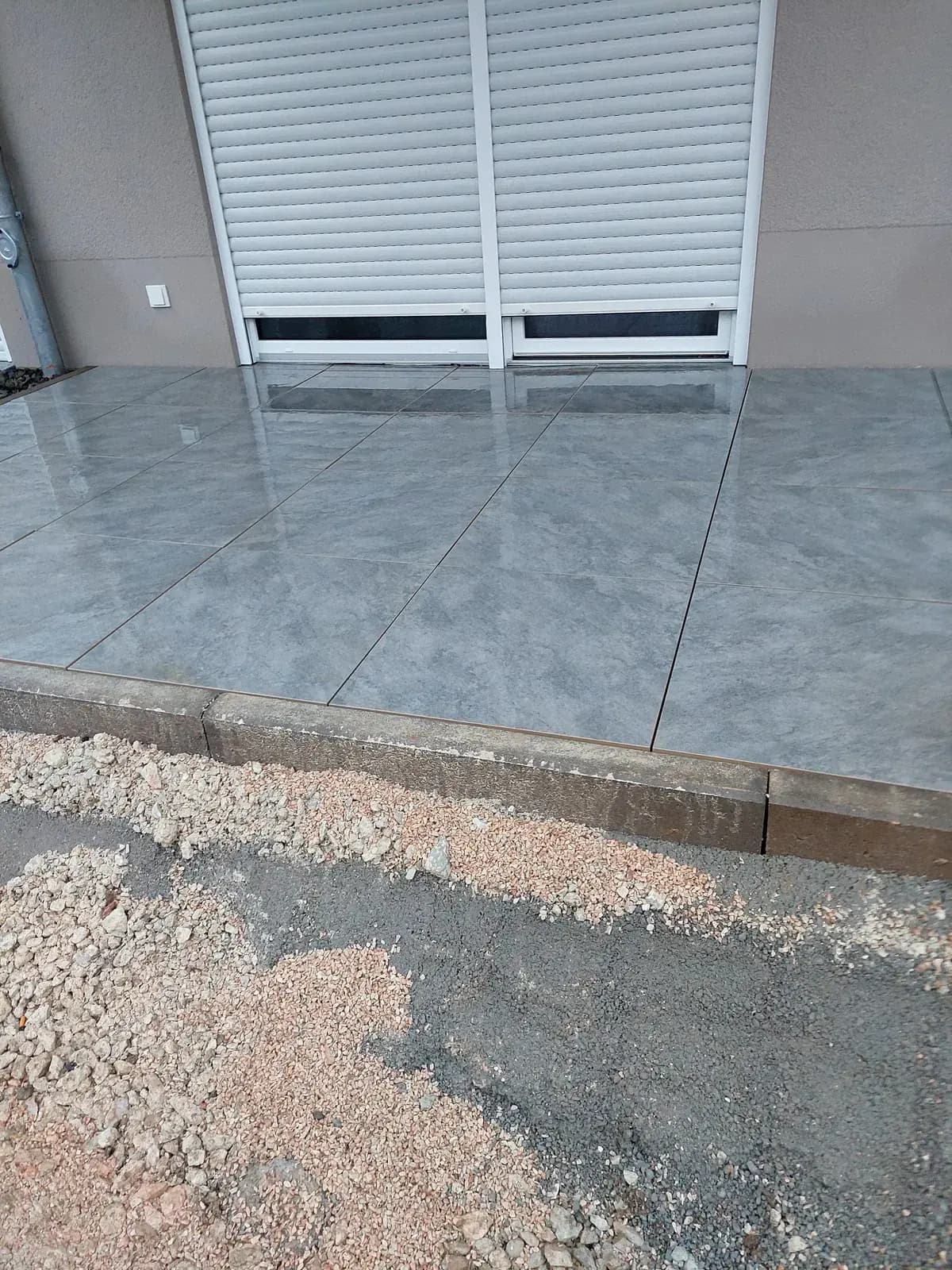 Neu gebaute Terrasse mit großformatigen Feinsteinzeugplatten in Marmoroptik – Terrassenbau von SHG Galabau in Bad Kreuznach